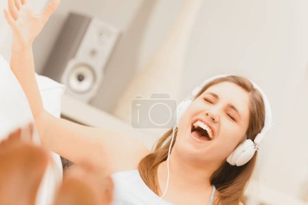 young female singing freely, her headphones transmitting the beats that drive her movements