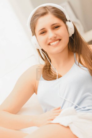 Allongée dans son salon, l'expression de contentement des femmes est évidente lorsqu'elle écoute attentivement la musique. 
