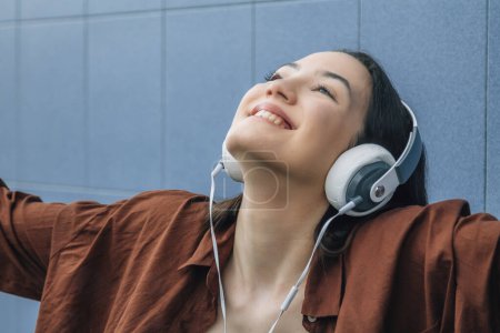 Relaxed happy girl with headphones on the street