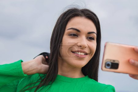Téléchargez les photos : Souriant jeune femme faire un selfie avec caméra téléphonique - en image libre de droit