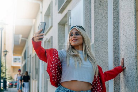 fille obèse dans la rue avec téléphone portable prenant un selfie ou vidéo en direct