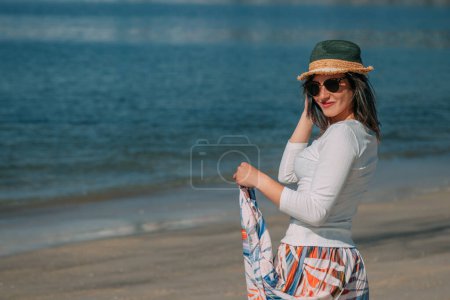smiling  young woman on beach in summer style fashion trend outfit carefree and happy, feeling freedom, boho style chic and sunglasses