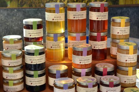 Téléchargez les photos : Castelnuovo don Bosco, Piémont, Italie -26-11-2023- Un étal de marché avec différentes variétés de pots de miel - en image libre de droit