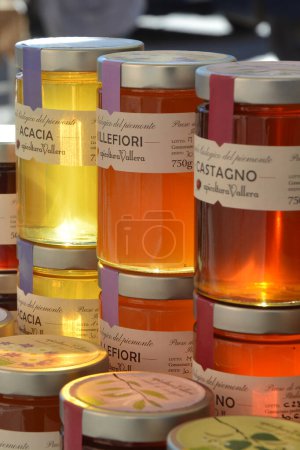 Téléchargez les photos : Castelnuovo don Bosco, Piémont, Italie -26-11-2023- Un étal de marché avec différentes variétés de pots de miel - en image libre de droit