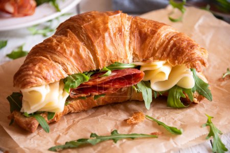 Croissant sandwich with cheese and arugula