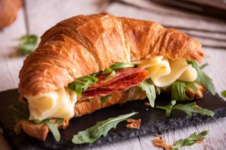 Croissant sandwich with cheese and arugula