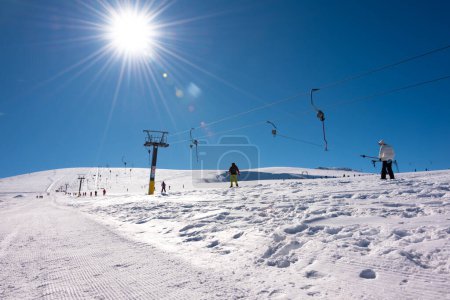 Téléchargez les photos : Personnes utilisant un téléski le jour ensoleillé d'hiver sur une station i - en image libre de droit