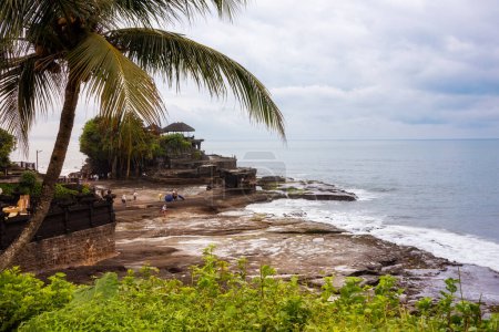 Photo for Tanah lot hindu temple seen from a palm tree on Bali in Indonesia - Royalty Free Image