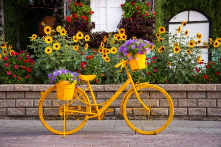Foto de Bicicleta amarilla con flores en un hermoso jardín - Imagen libre de derechos