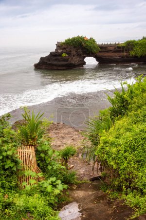 Téléchargez les photos : Arc rocheux avec un temple et des plantes vertes sur l'île de Bali, Indonésie - en image libre de droit