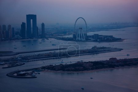 Dubais Skyline bei Sonnenuntergang, moderne Stadt mit Wolkenkratzern vom Wasser aus gesehen