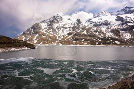 Téléchargez les photos : Lac de montagne avec glace et neige en Suisse au printemps - en image libre de droit
