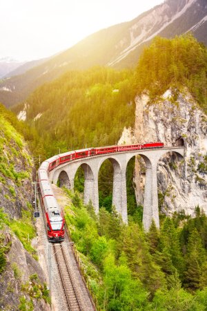 Foto de Tren rojo suizo en viaducto en la montaña para el paseo escénico - Imagen libre de derechos