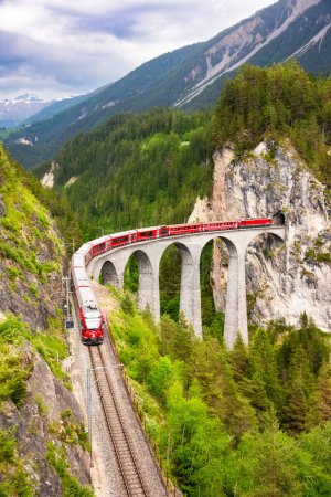 Schweizer Roter Zug auf Viadukt in Berg für malerische Fahrt