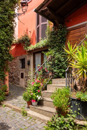 Téléchargez les photos : Rue étroite de petite ville avec de nombreuses plantes vertes en Italie - en image libre de droit