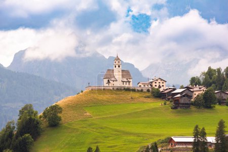 Foto de Vista panorámica del pueblo de montaña con iglesia en los Alpes Dolomitas - Imagen libre de derechos