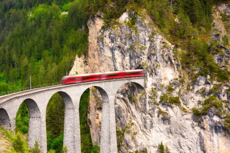 Photo for Swiss red train on viaduct in mountain for scenic ride - Royalty Free Image