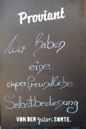 Photo for A black board with German text written on it: We have a super friendly self-service. - Royalty Free Image