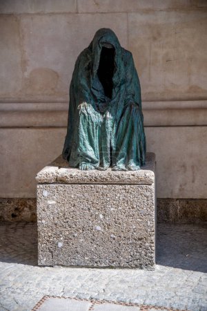 Photo for Salzburg - Salzburg - Austria - 06-17-2021: Anna Chromy's sculpture "Pieta" on a pedestal, half-shadowed. The figure, in a floor-length cloak, features a faceless void. - Royalty Free Image