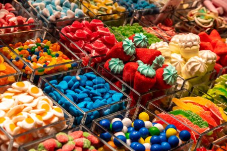 Lots of colorful sweets in different bowls. All the colors are very intense and some of the candy has been used to imitate fruit