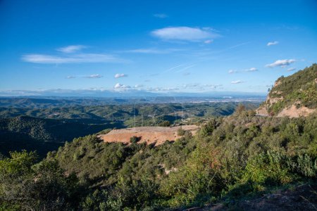 Foto de Vista sobre las montañas de Montserrat. Cuando el cielo es azul, se puede ver una meseta que se encuentra en medio de los bosques. - Imagen libre de derechos