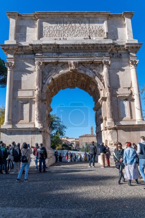 Téléchargez les photos : Rome, Latium - Italie - 23-11-2022 : Arc de l'empereur Titus, arc de triomphe à l'entrée du Forum romain, orné de colonnes et de chapiteaux, admiré par de nombreux touristes - en image libre de droit