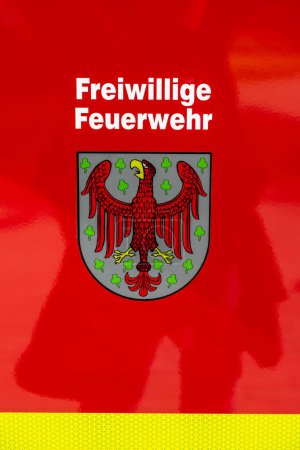 Foto de Templin, Brandeburgo - Alemania - 06-09-2022: Primer plano del vibrante emblema que simboliza el orgulloso servicio de un cuerpo de bomberos voluntarios - Imagen libre de derechos