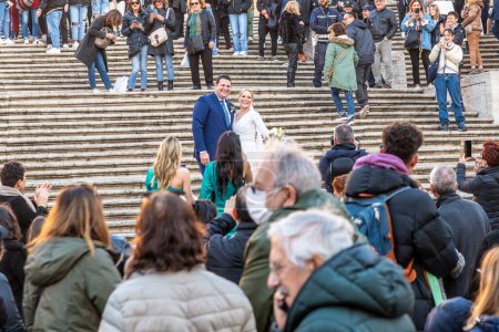 Photo for Roma, Latium - Italy - 11-27-2022: A couple exchanges vows on historic steps, surrounded by an audience of both invited guests and casual onlookers, under the open sky - Royalty Free Image