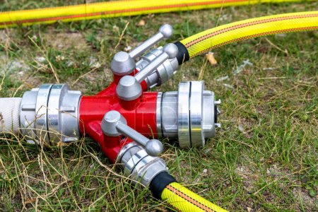 Photo for Precision equipment for firefighting: A dividing manifold lying on the grass during a demonstration - Royalty Free Image