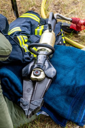 Close-up view of a firefighter's hydraulic rescue tool, crucial for extrication, alongside protective gear