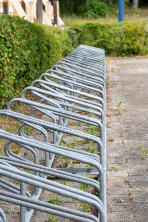 Photo for A long, vacant bike rack awaits visitors in a serene park setting - Royalty Free Image