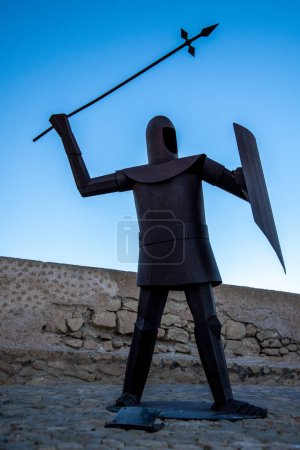 Photo for Alicante, Alicante - Spain - 01-07-2024: A bold sculpture of a knight with a spear stands against the sky in Alicante, casting a striking silhouette - Royalty Free Image