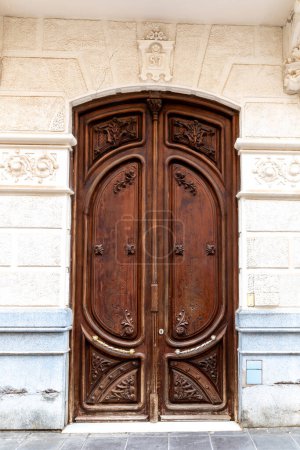 Téléchargez les photos : Carthagène, Murcie - Espagne - 16-01-2024 : Portes doubles en bois cintrées, finement sculptées avec une plaque de numéro délicate, reflétant l'architecture classique - en image libre de droit