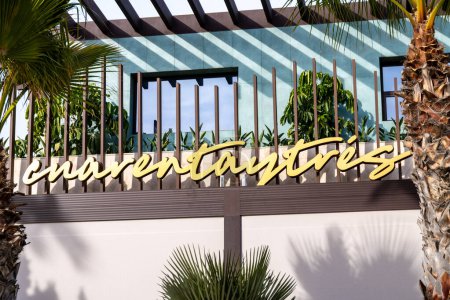 Téléchargez les photos : Cartagena, Murcie - Espagne - 16-01-2024 : Signe d'or du Licor 43, ou Cuarenta y Tres, au siège de la marque au milieu des palmiers ensoleillés de Cartagena, Espagne - en image libre de droit
