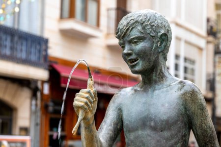Photo for Cartagena, Murcia - Spain - 01-16-2024: Bronze statue 'El Icue' depicting a boy with a fish, a notable public art piece in Cartagena, Spain, created in 1969 - Royalty Free Image