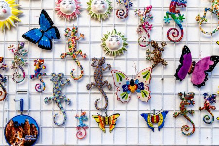 Photo for El Castell de Guadalest, Alicante - Spain - 12-27-2023: Vibrant ceramic suns, butterflies, and geckos adorn a wall in Guadalest, showcasing local art - Royalty Free Image
