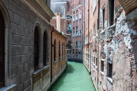 Téléchargez les photos : Venise, Vénétie - Italie - 06-09-2021 : Une voie navigable isolée serpente entre les murs altérés de Venise quartier calme - en image libre de droit