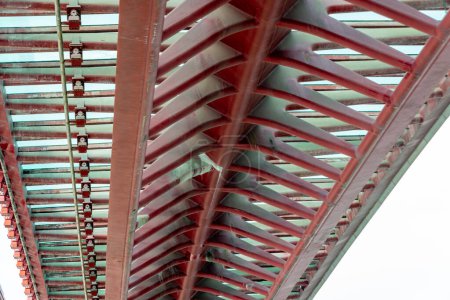 Venice, Veneto - Italy - 06-10-2021: Underside view of Venice Constitution Bridge, showing a close-up of red steel truss design