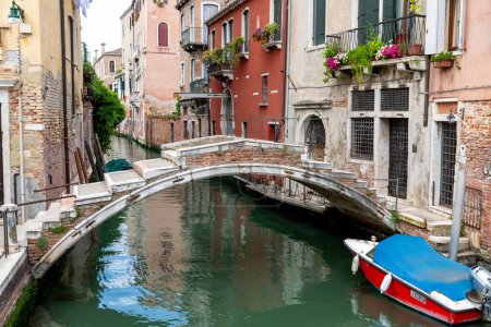Téléchargez les photos : Venise, Vénétie - Italie - 06-10-2021 : Charmant canal vénitien bordé de bâtiments historiques et d'un pont en pierre voûté - en image libre de droit
