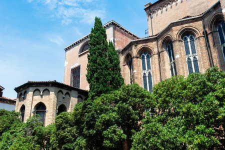 Téléchargez les photos : Venise, Vénétie - Italie - 06-09-2021 : Bâtiment historique en brique avec de hautes fenêtres entourées d'arbres denses à Venise - en image libre de droit
