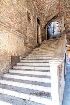 Téléchargez les photos : Vicence, Vénétie - Italie - 06-12-2021 : Un escalier médiéval fermé par une porte en fer forgé mène sous un passage voûté à la basilique Palladiana à Vicence - en image libre de droit