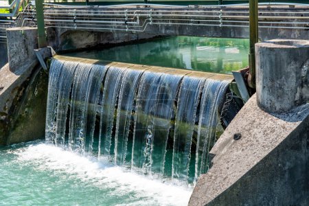 Treviso, Venetien - Italy - 06-13-2021: Close-up of an industrial water locks amidst greenery, part of Treviso historic water control systems