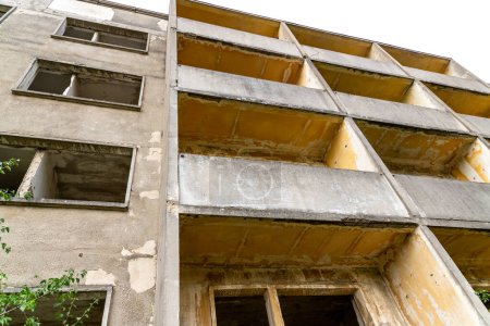 Elstal, Brandebourg - Allemagne - 28-09-2021 : Ancien bâtiment préfabriqué laissé à la décomposition, sans fenêtres avec balcons qui deviennent lentement envahissants