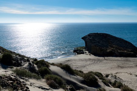 Cabo de Gata, Almeria - Spain - 01-23-2024: Silhouetted rock formations and sparkling sea under the bright sunlight at Cabo de Gata