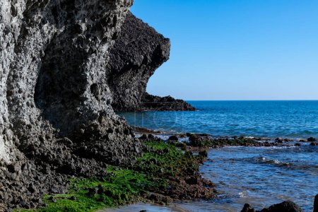 Cabo de Gata, Almeria - Spain - 01-23-2024: Volcanic archway on rocky beach against blue sea in Cabo de Gata