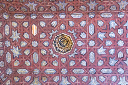 Elaborate arabesque patterns adorn Alhambra Nasrid Palaces ceiling, showcasing Islamic artistry