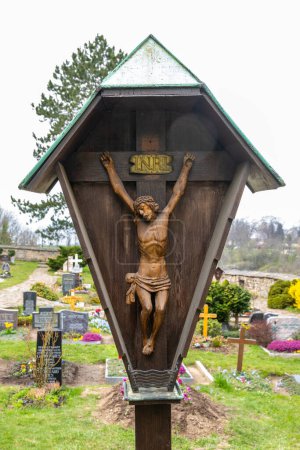 Photo for Bautzen, Saxony - Germany - 04-10-2021: A wooden crucifix with the inscription INRI stands amidst graves, symbolizing faith and remembrance - Royalty Free Image