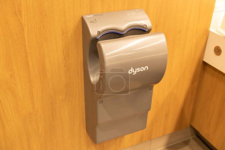 Photo for Bautzen, Saxony - Germany - 04-10-2021: A Dyson Airblade hand dryer mounted on a wooden wall in a public restroom, with a sleek design - Royalty Free Image