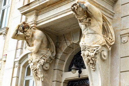 Téléchargez les photos : Loebau, Saxe - Allemagne - 17-04-2021 : Des caryatides de pierre aux sculptures complexes ornent une entrée architecturale à Loebau, reflétant l'art historique - en image libre de droit