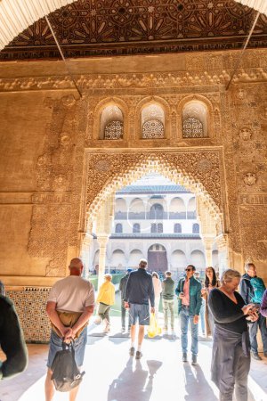Foto de Granada, Granada - España - 30-01-2024: Los visitantes admiran las intrincadas tallas moriscas en los soleados Palacios Nazaríes, la joya histórica de la Alhambra - Imagen libre de derechos